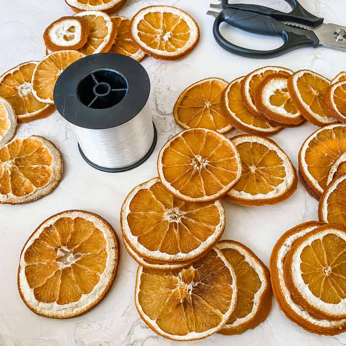 Threading the dried orange slices on fishing wire