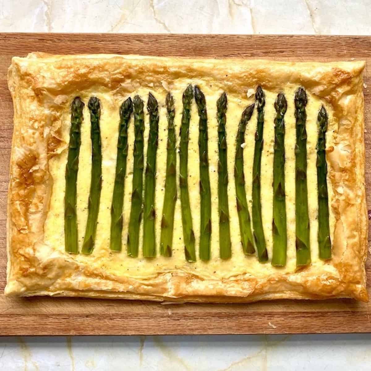 Easy asparagus tart for Spring luncheon on a wooden serving board. 