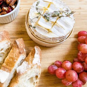 Food on the cutting board, with Camembert and bread.