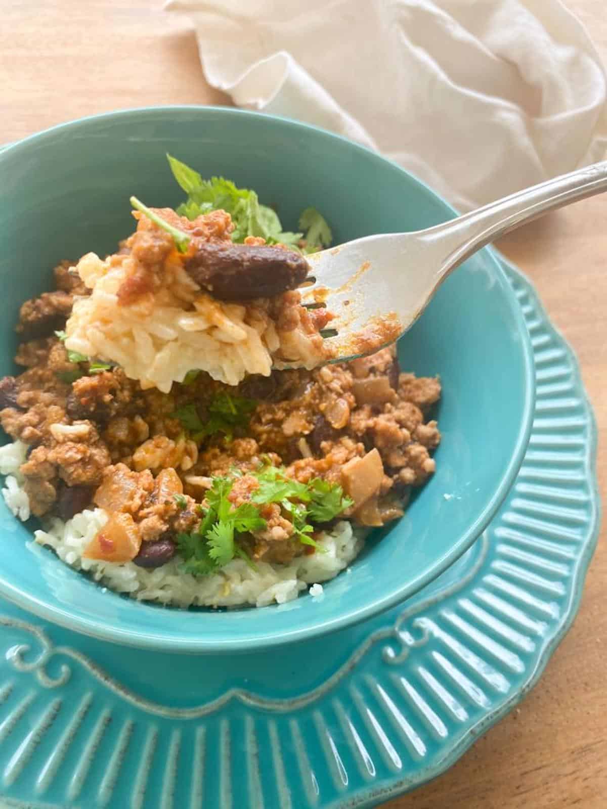 A plate of food on a table, with Pork chilli con carne.