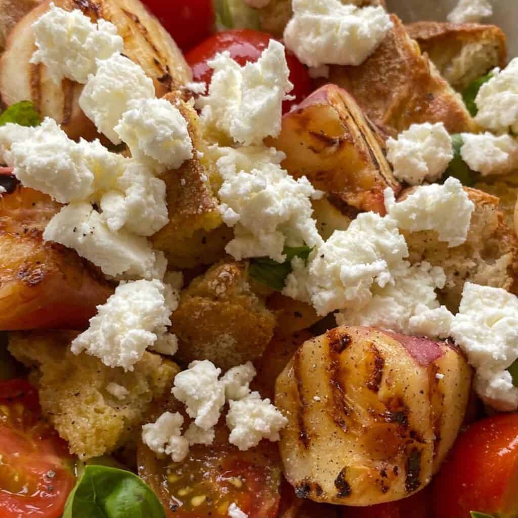 crumbled feta on a peach panzanella salad