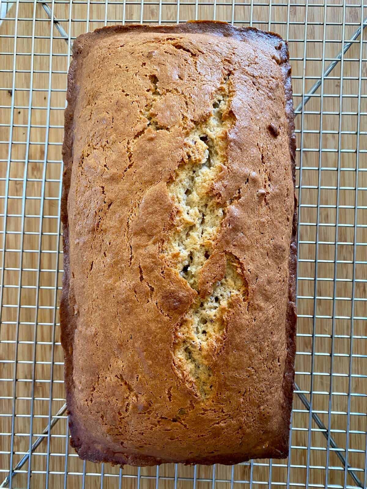Freshly baked banana bread with pecans on a cooling rack