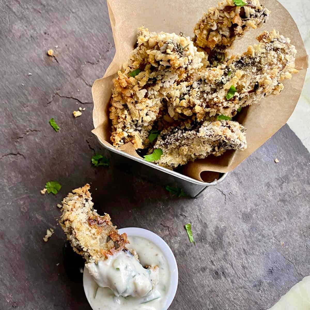 A bowl of panko breaded mushrooms and dipping sauce on a canapé tray 