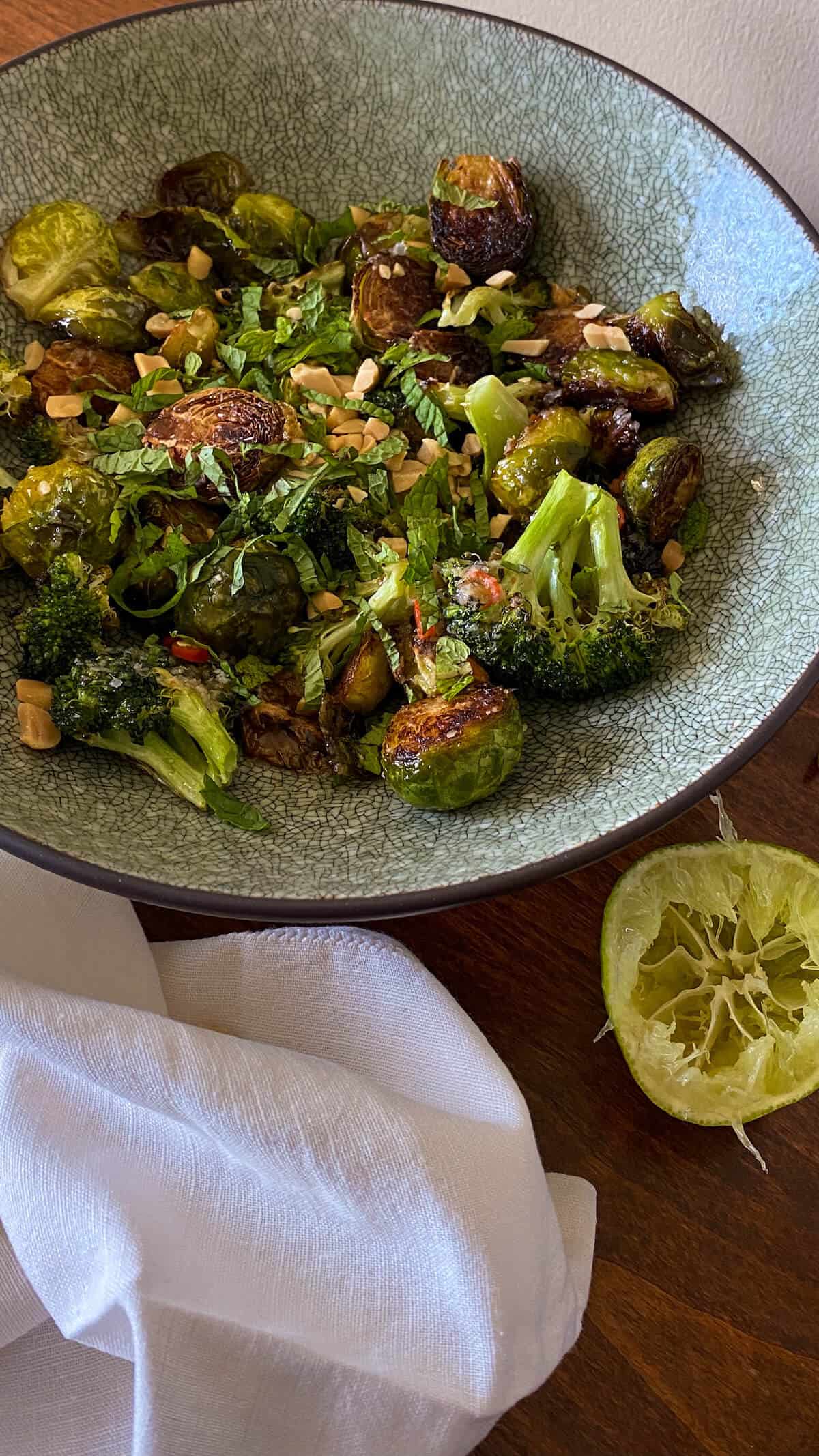 a bowl of honey sriracha Brussel sprouts and broccoli with spicy peanut vinaigrette 