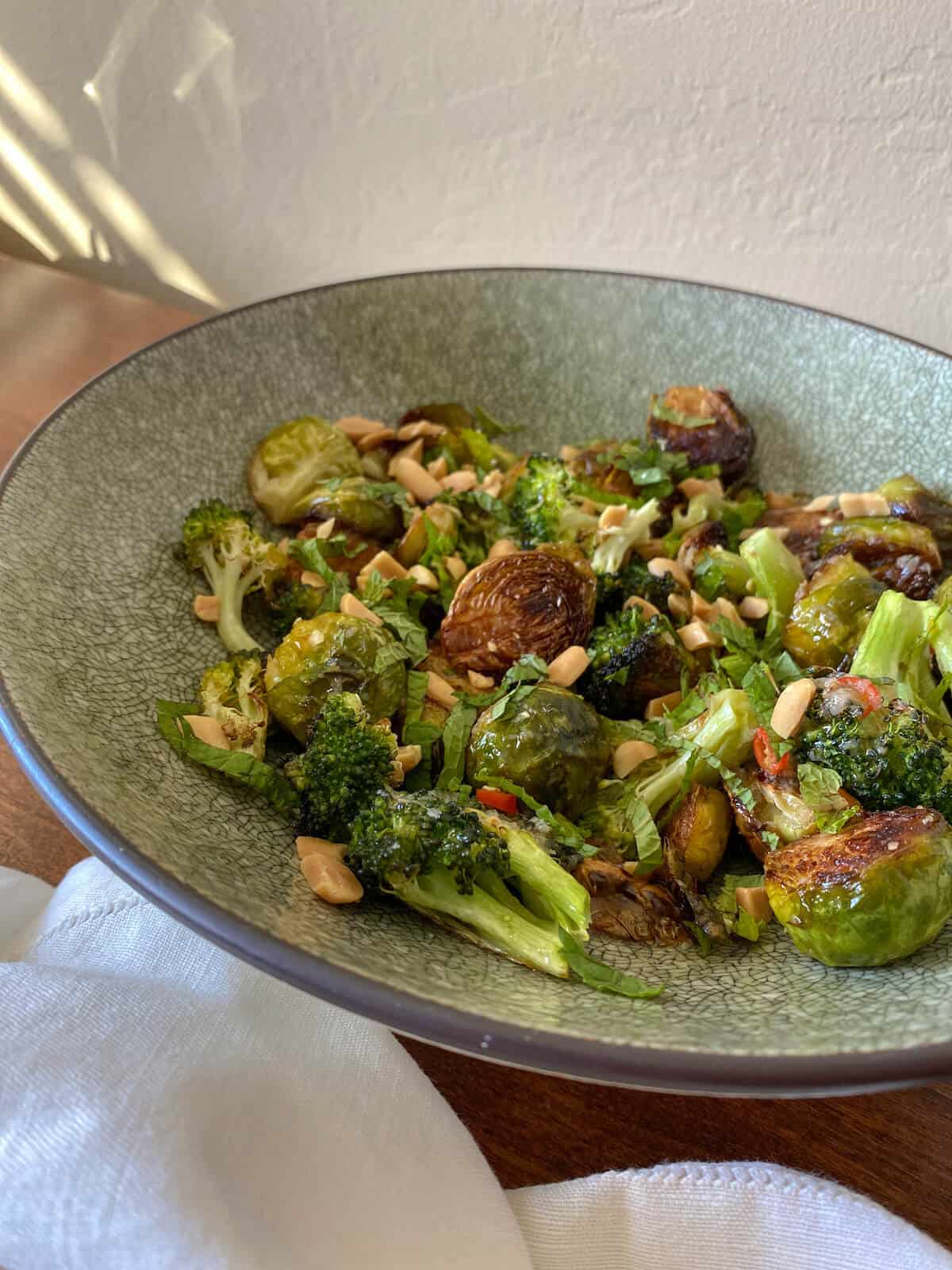 A bowl of charred brussel sprouts and broccoli salad with peanuts 