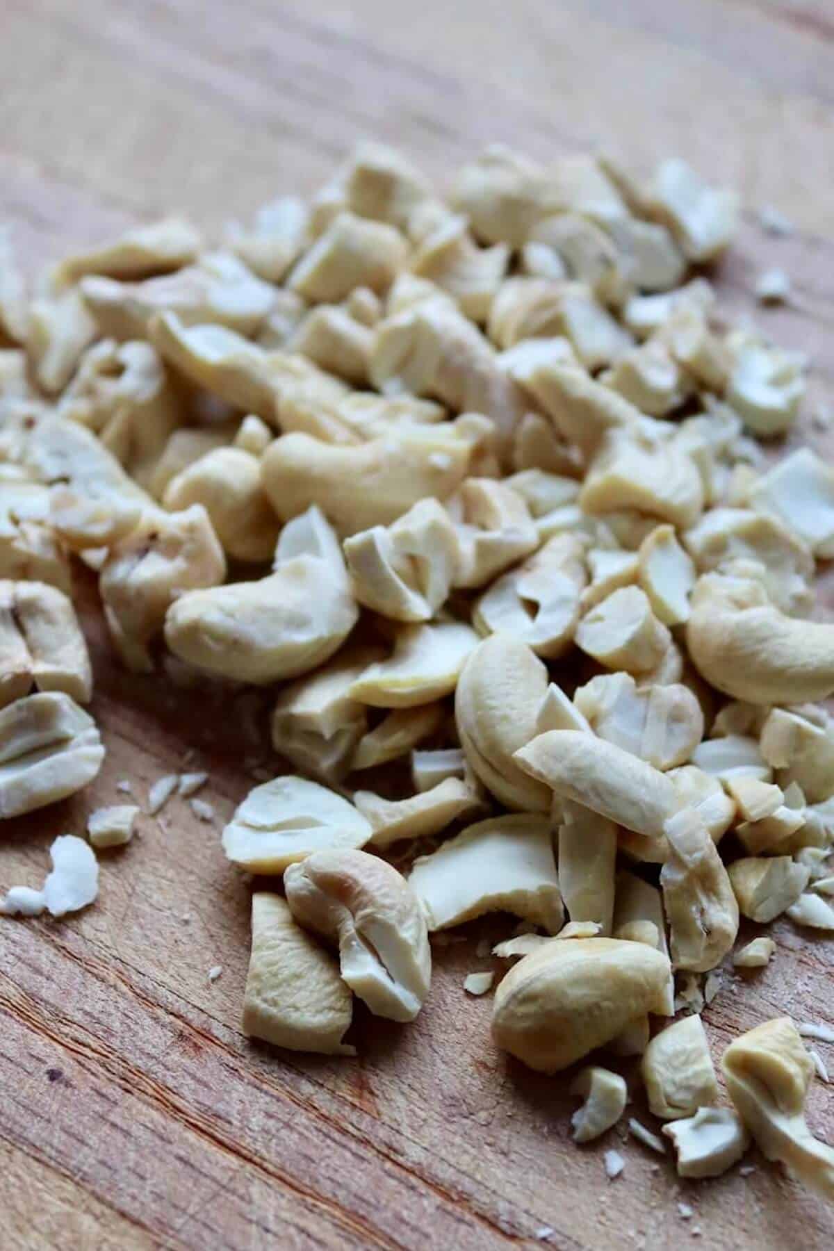 Chopped cashew nuts on a wooden chopping board 