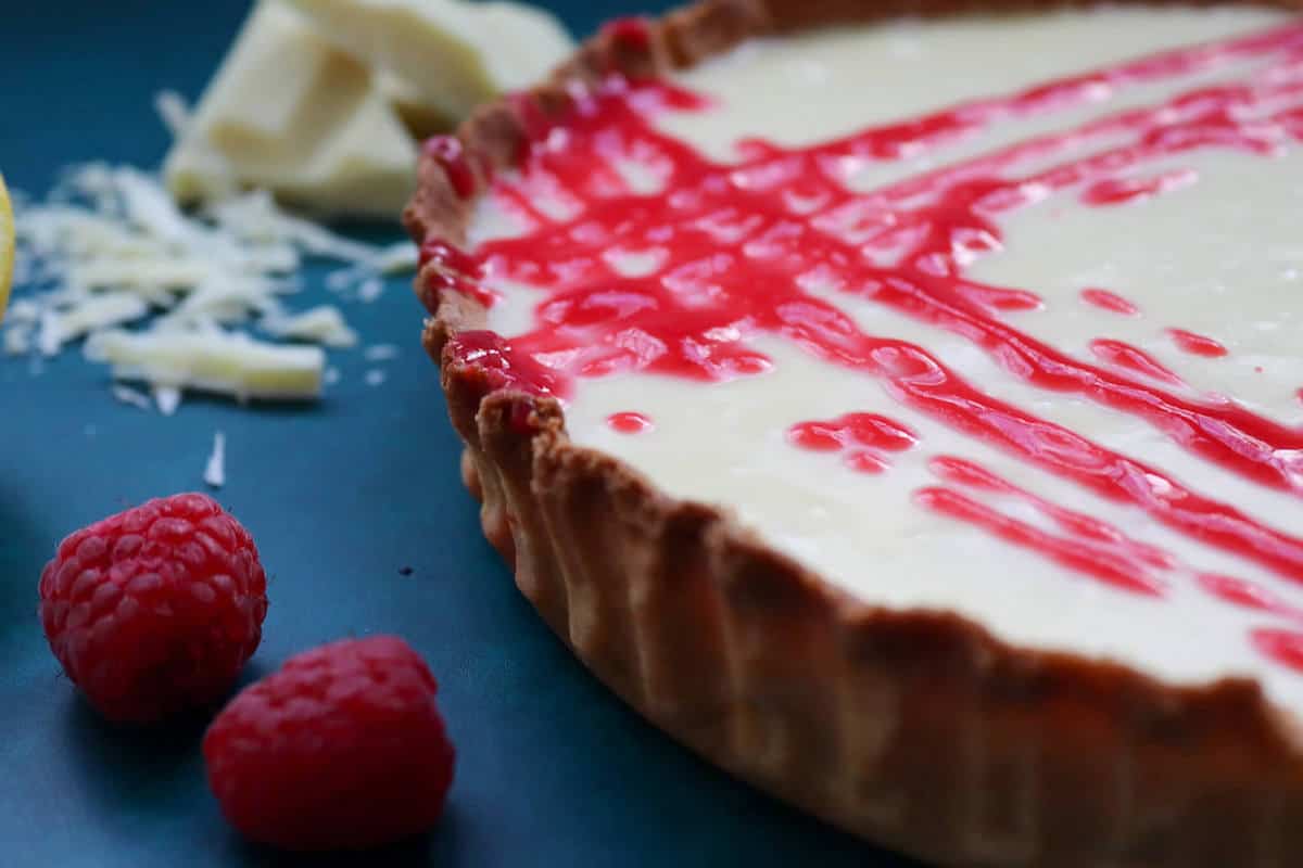 A white chocolate tart with lemon pastry crust and raspberry coulis 