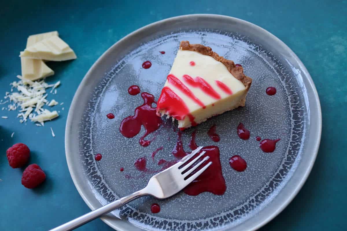 A serving of white chocolate tart with raspberry coulis