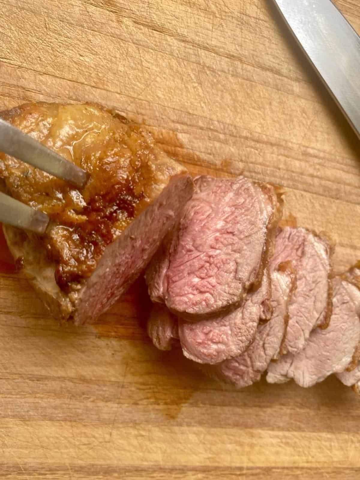 Carved lamb rump roast on a wooden carving board
