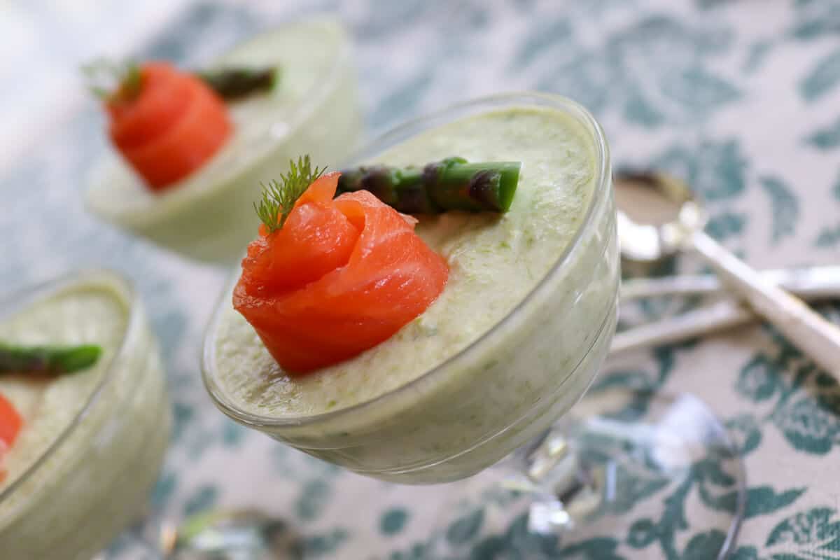 Glasses with asparagus mousse amuse bouche and smoked trout on top. 