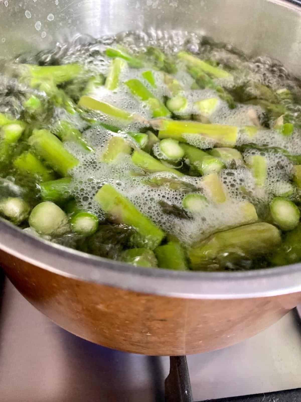 asparagus spears in a saucepan of boiling water. 