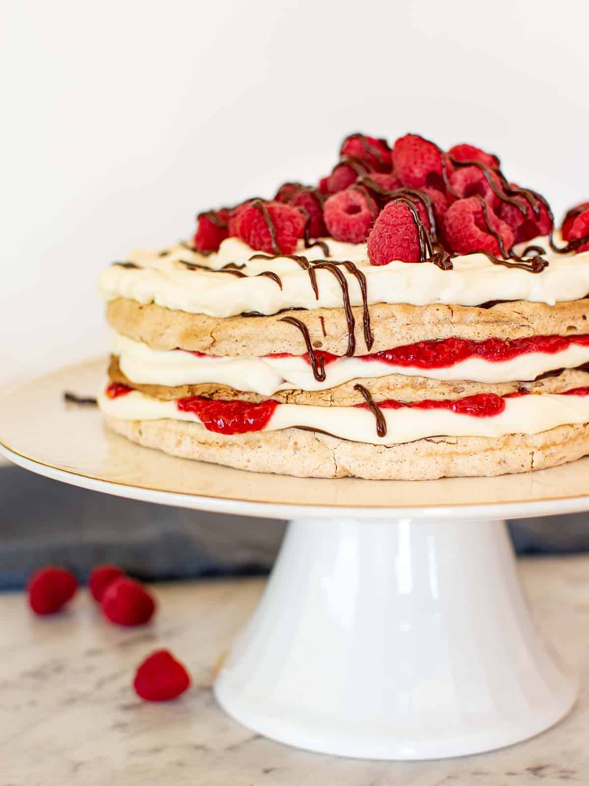 A layered raspberry torte on a cake stand