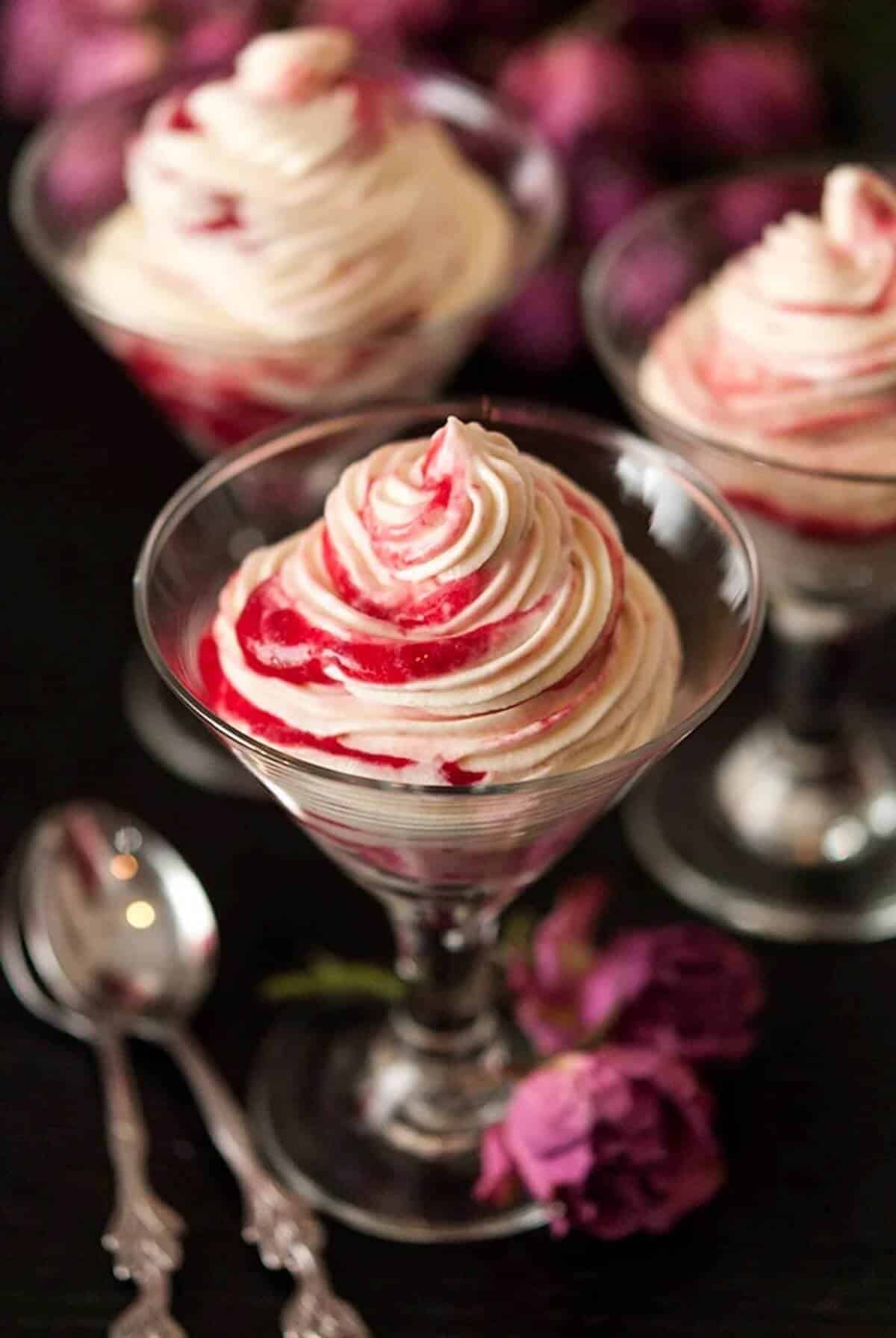 Martini glasses filled with white chocolate cheesecake, shot through with raspberry compote ribbons. 