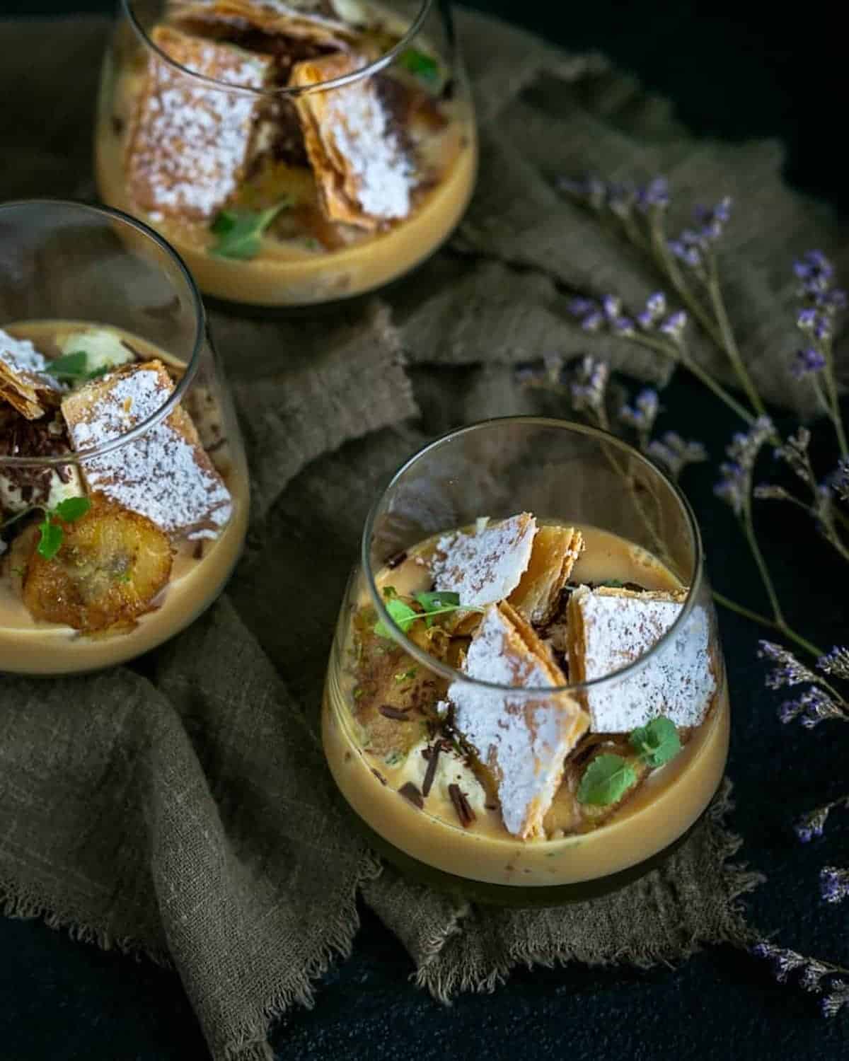 Glasses of dulce de lyche topped with shards of puff pastry