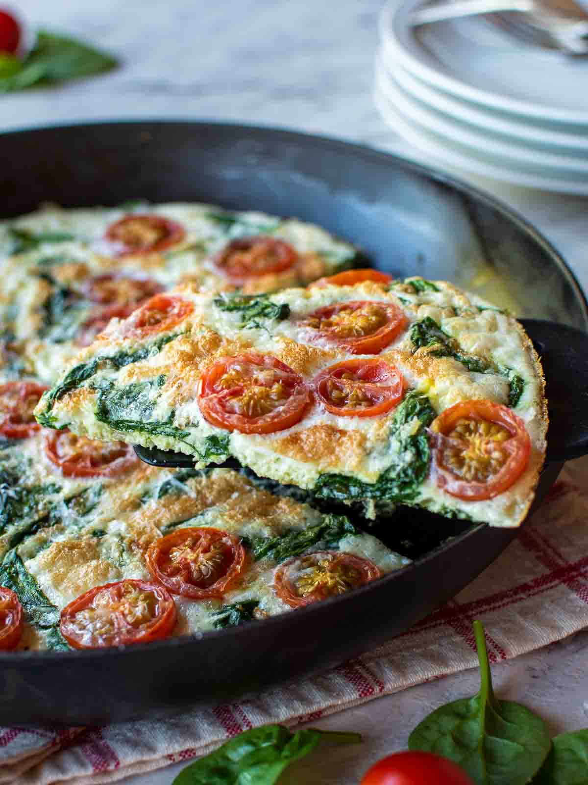 A cast iron skillet with a cooked egg white frittata in it about to be served.