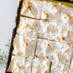 A tray of lemon meringue pie bars cut into squares.
