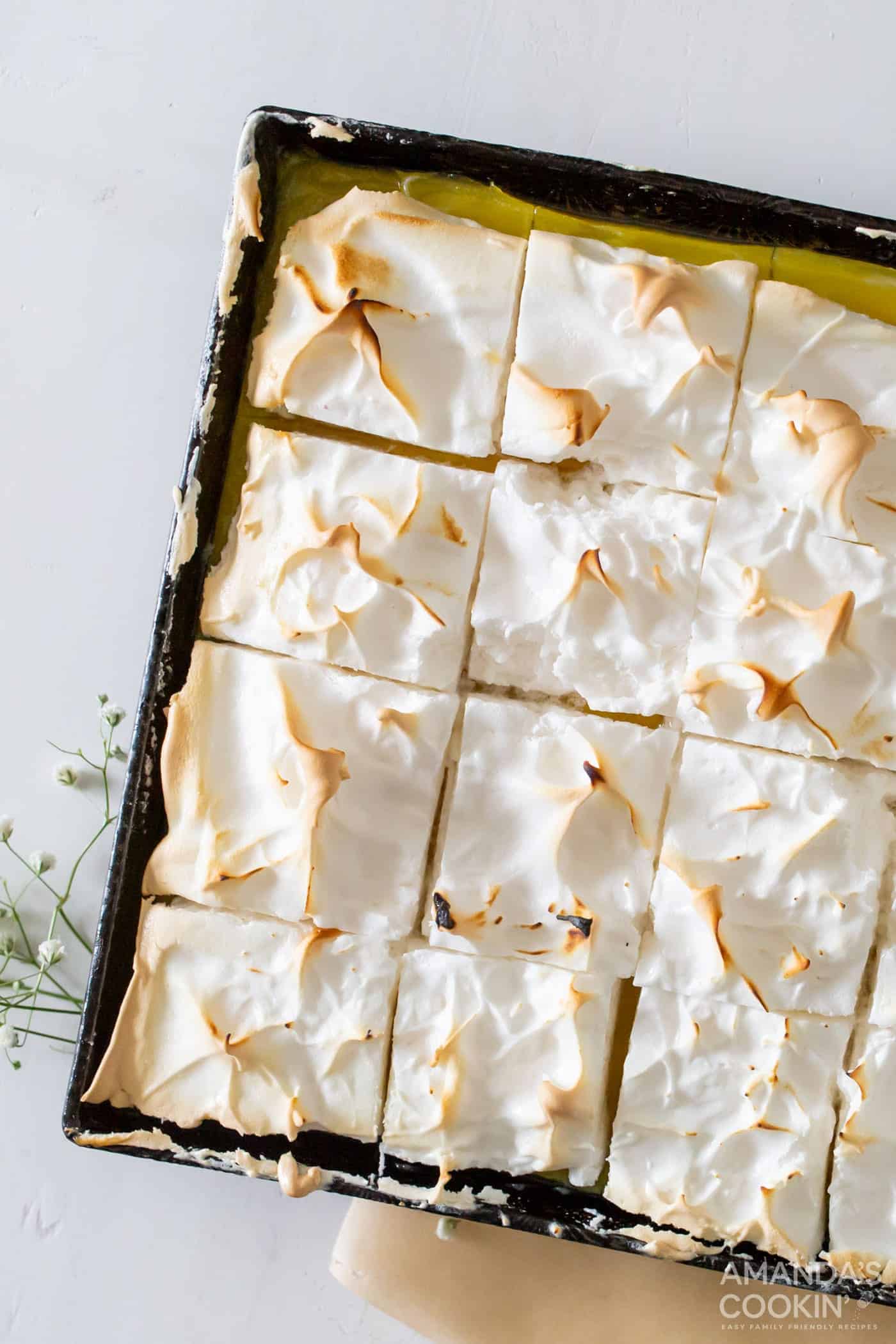 A tray of lemon meringue pie bars cut into squares.