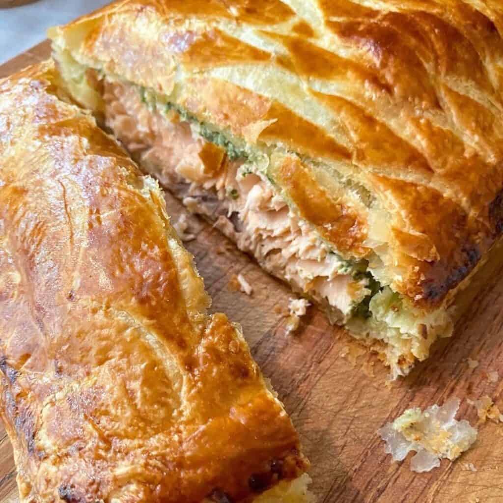 roast salmon en croute on a chopping board.