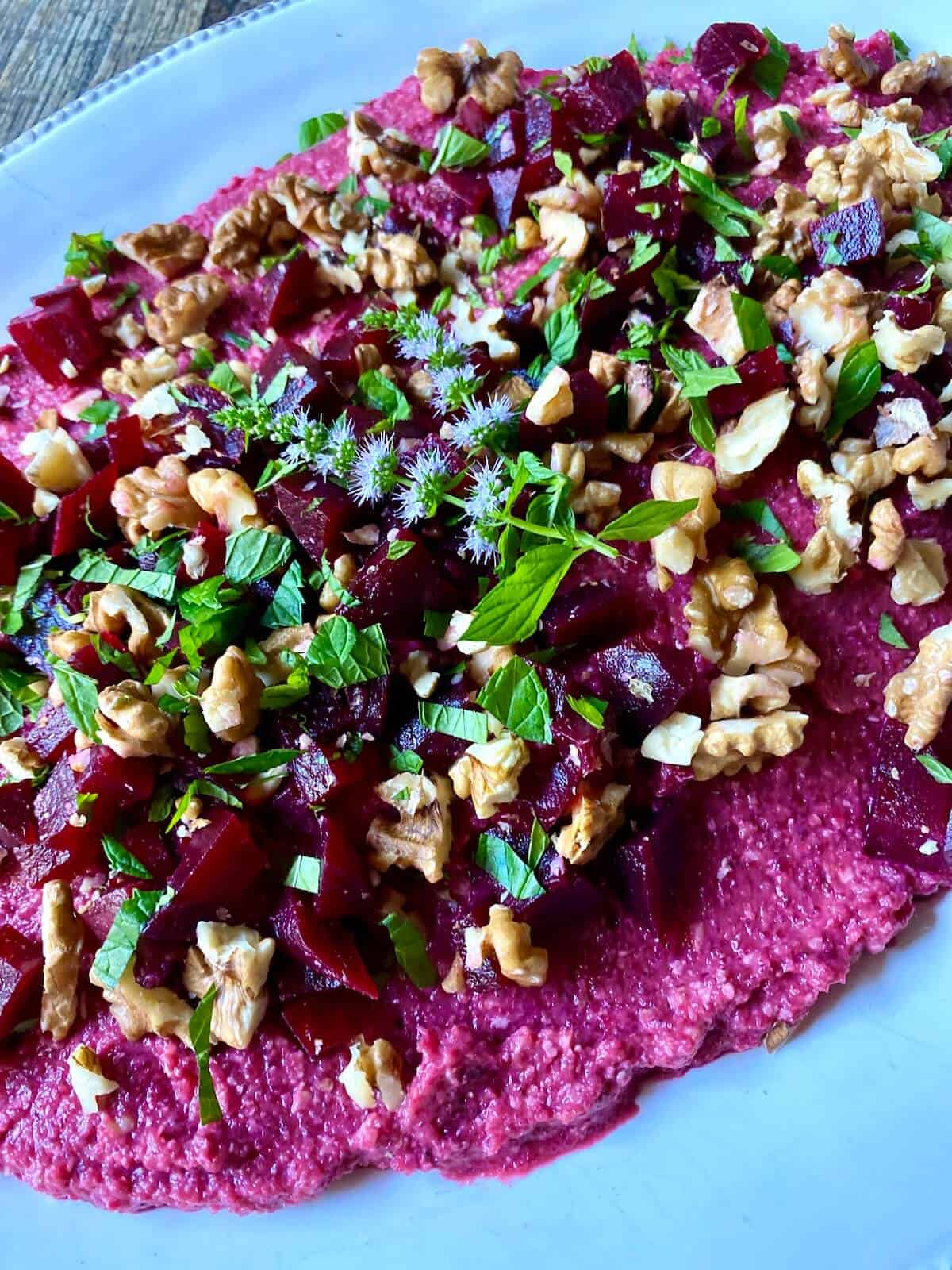 A vividly coloured beetroot hummus on a serving plate. 