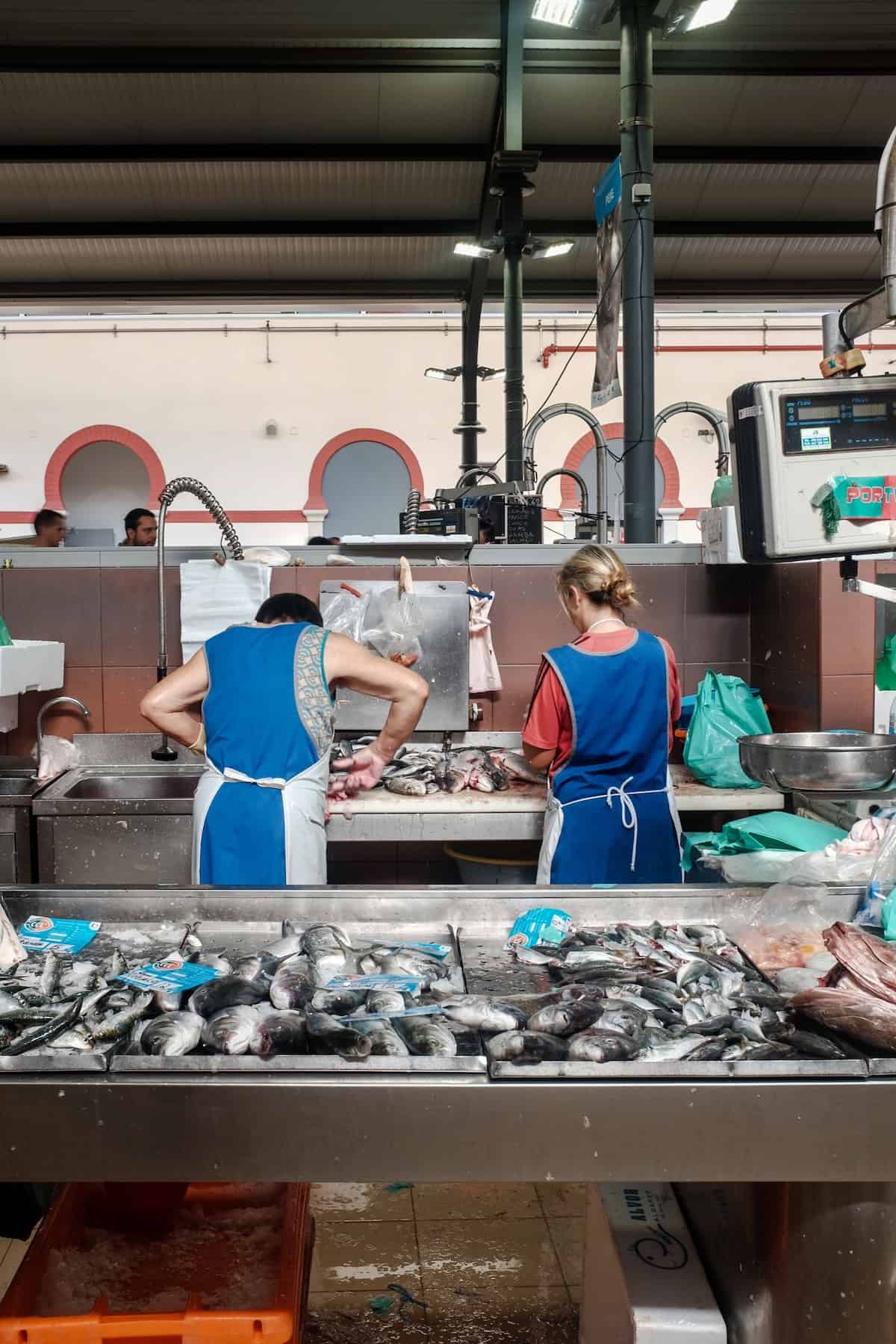 Two women working in Olhão fish market in Portugal.