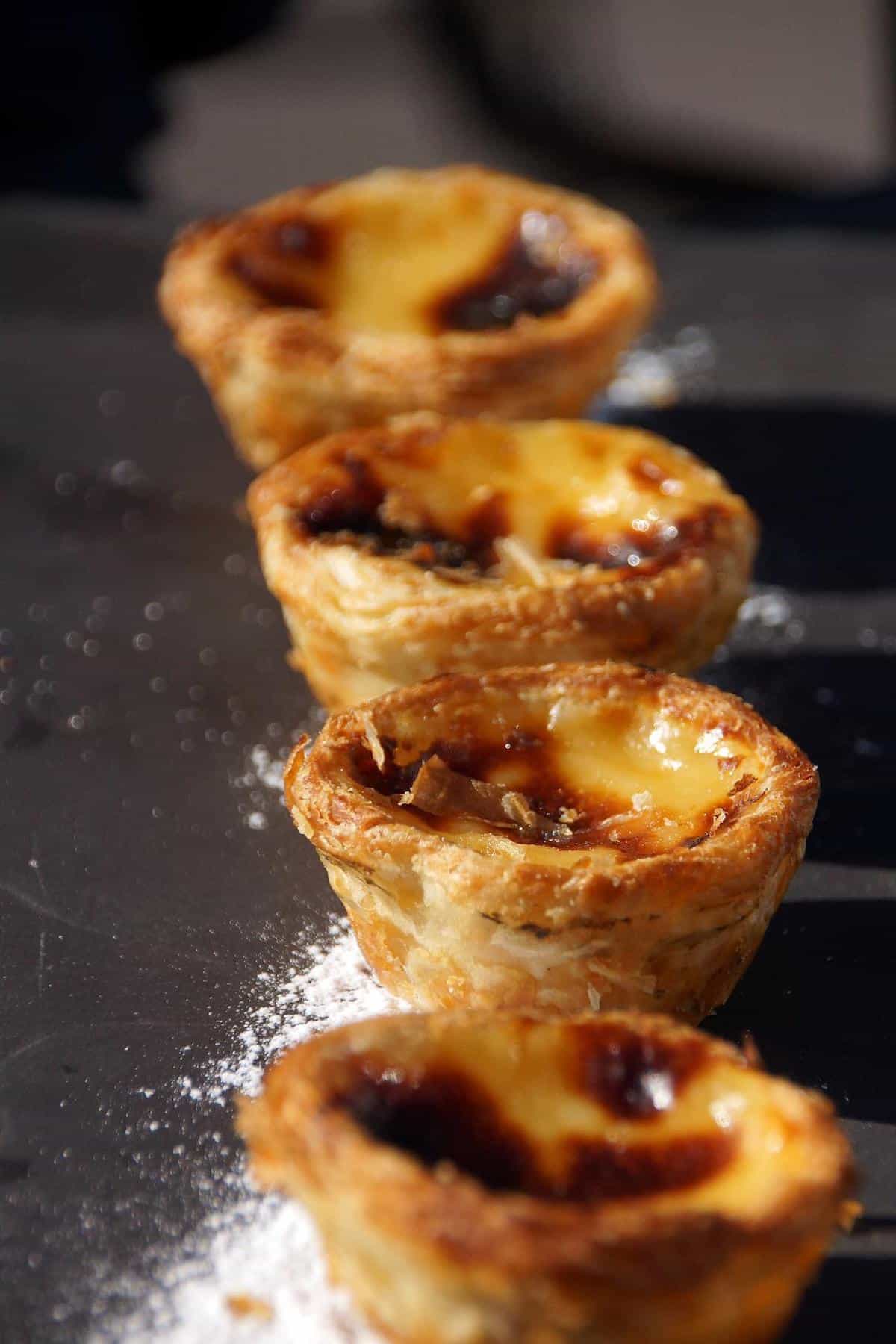 Custard tarts, a traditional Portuguese food known as pastéis de Nata on a serving platter. 