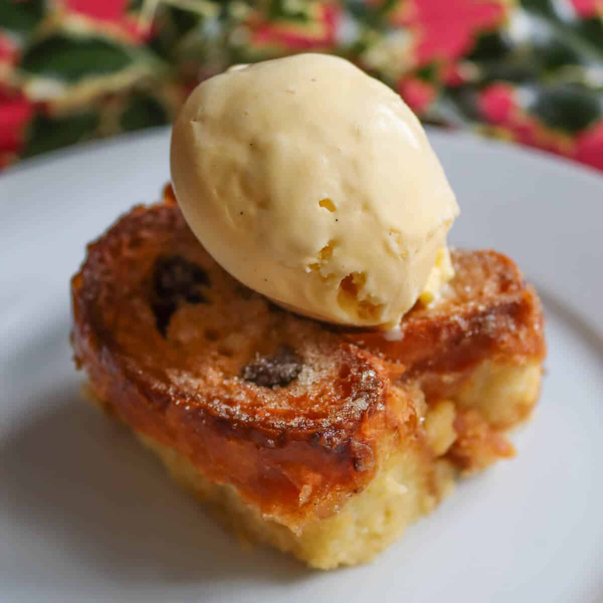 A serving of pain au chocolat pudding with a scoop of vanilla ice cream on top. 