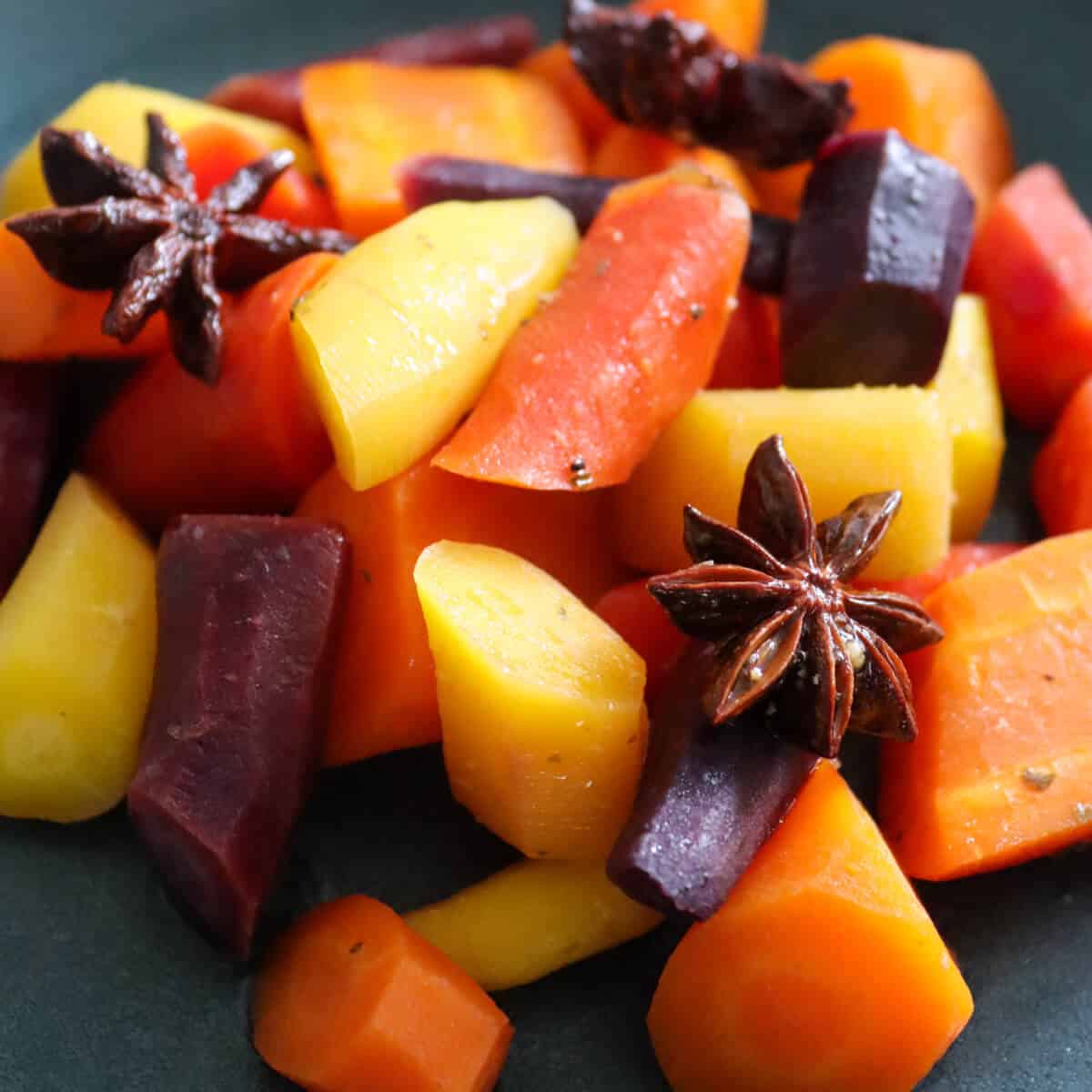 Rainbow Carrots cooked en papillote with star anise, in a serving bowl.