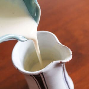 A champagne cream sauce being poured into a jug.