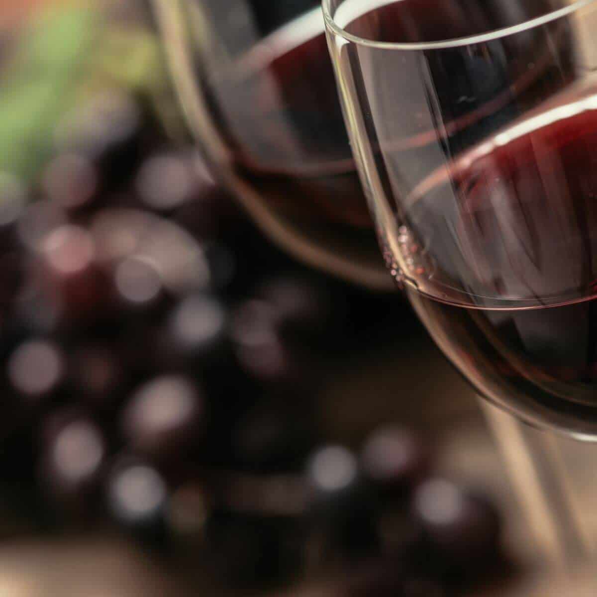 Red wine and grapes on a table.