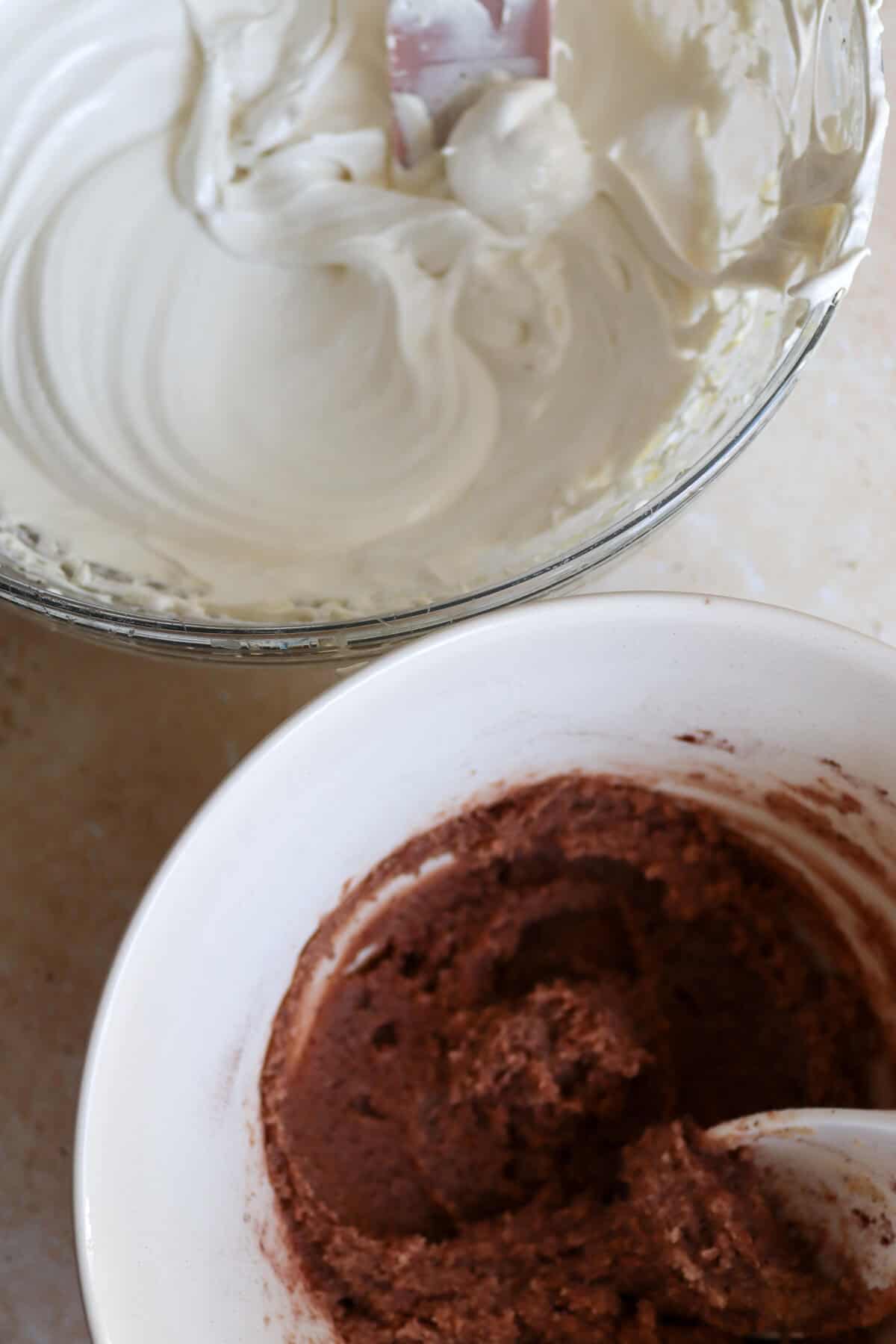 A bowl of Italian meringue next to a bowl of chocolate nut paste.