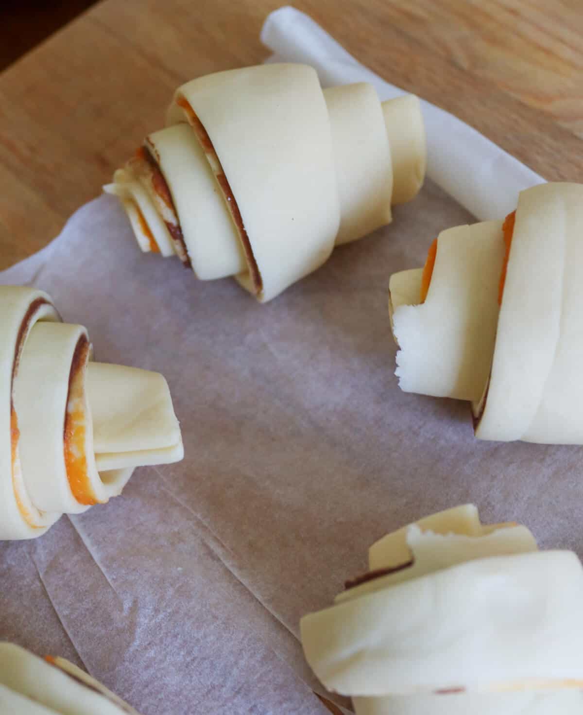 Puff pastry croissants on a surface about to be baked.