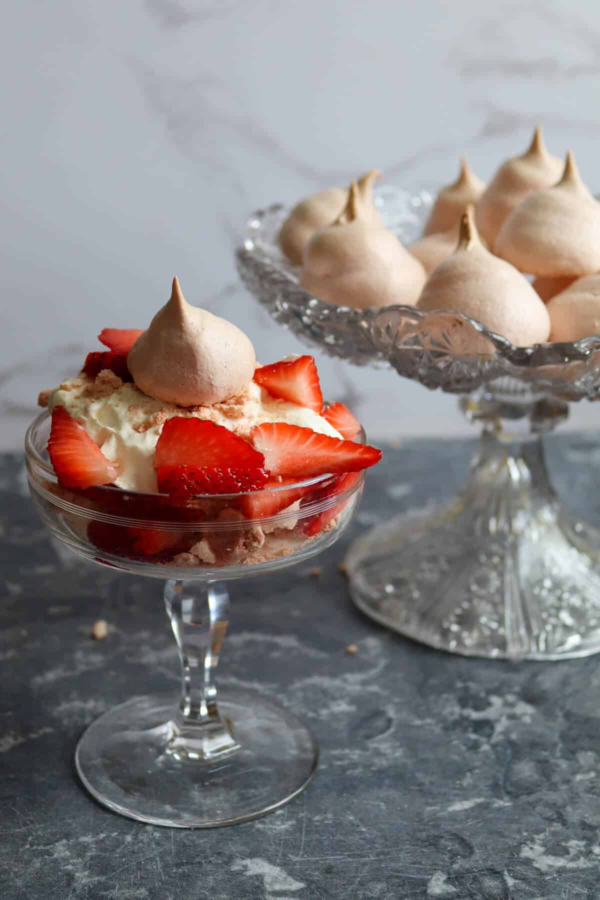 Eton Mess on a table with a bowl of meringue kisses.