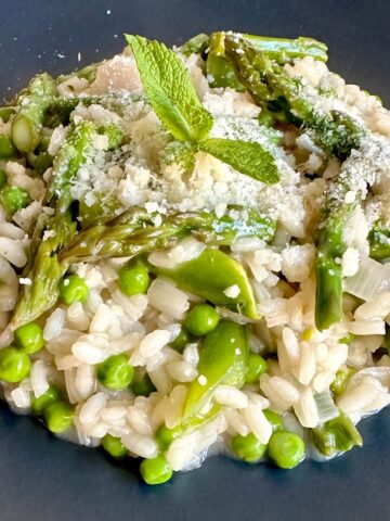 Spring vegetable risotto with asparagus and peas on a plate.