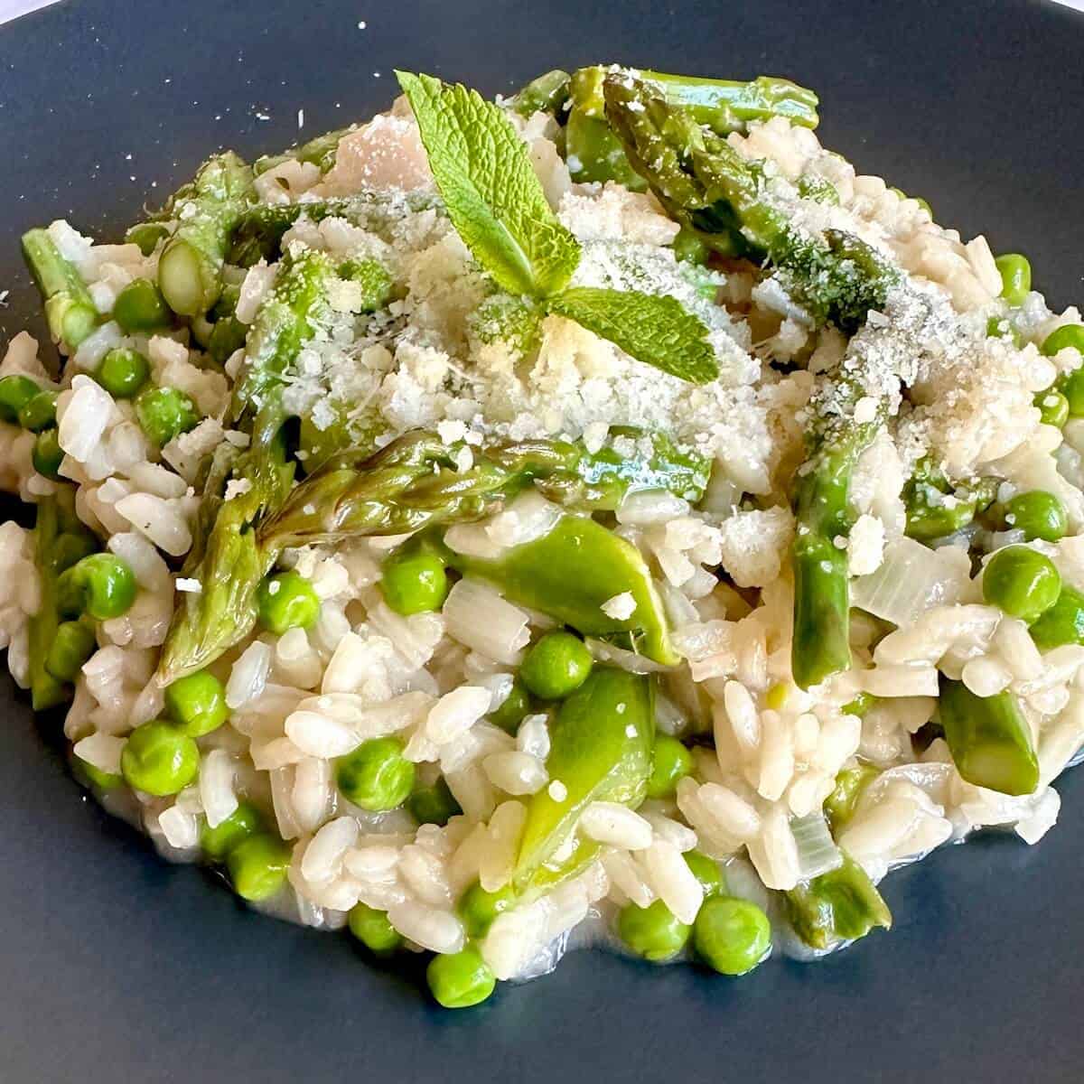 Spring vegetable risotto with asparagus and peas on a plate.