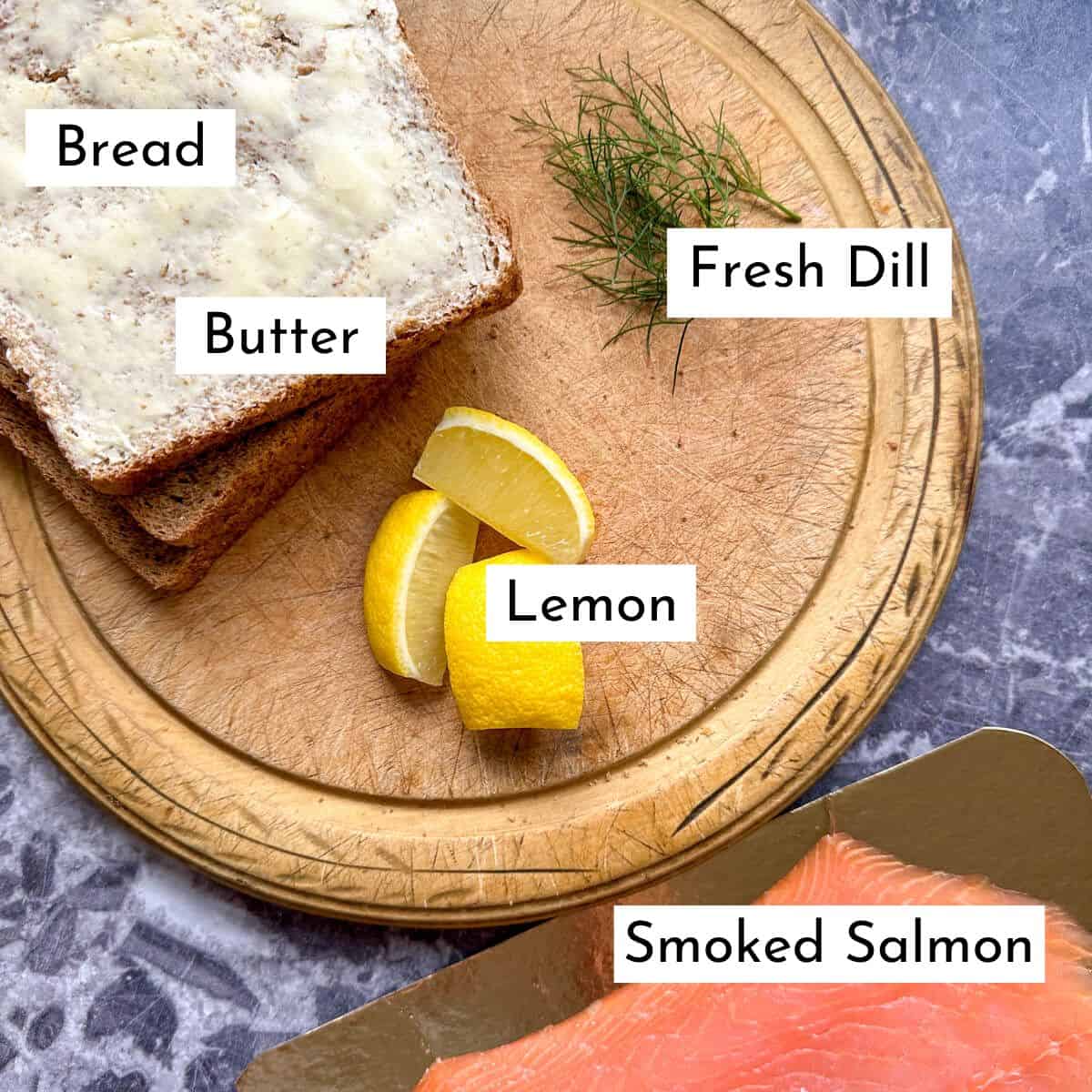 Ingredients for smoked salmon canapes. Bread, butter, dill, lemon and smoked salmon slices. 