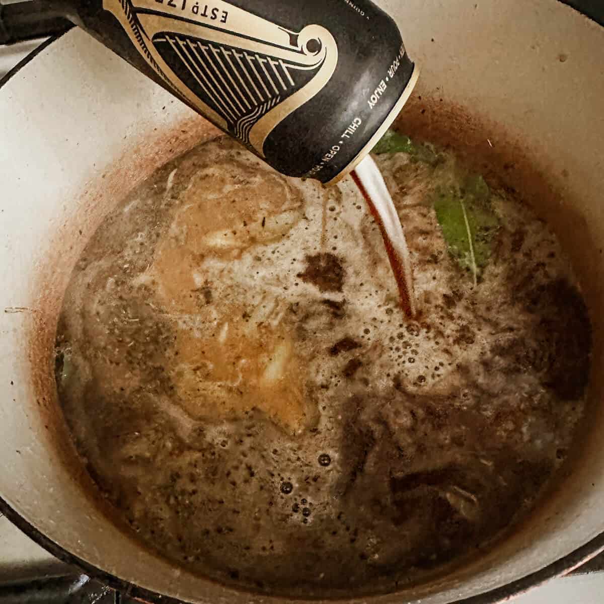 A can of Guinness being poured into the Dutch Oven. 