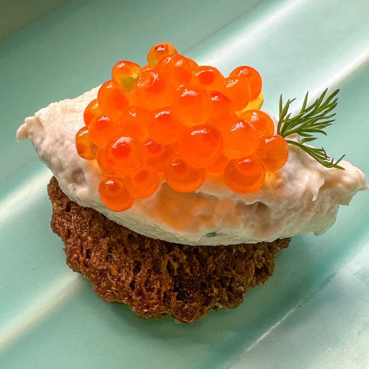 A canape topped with salmon roe. 