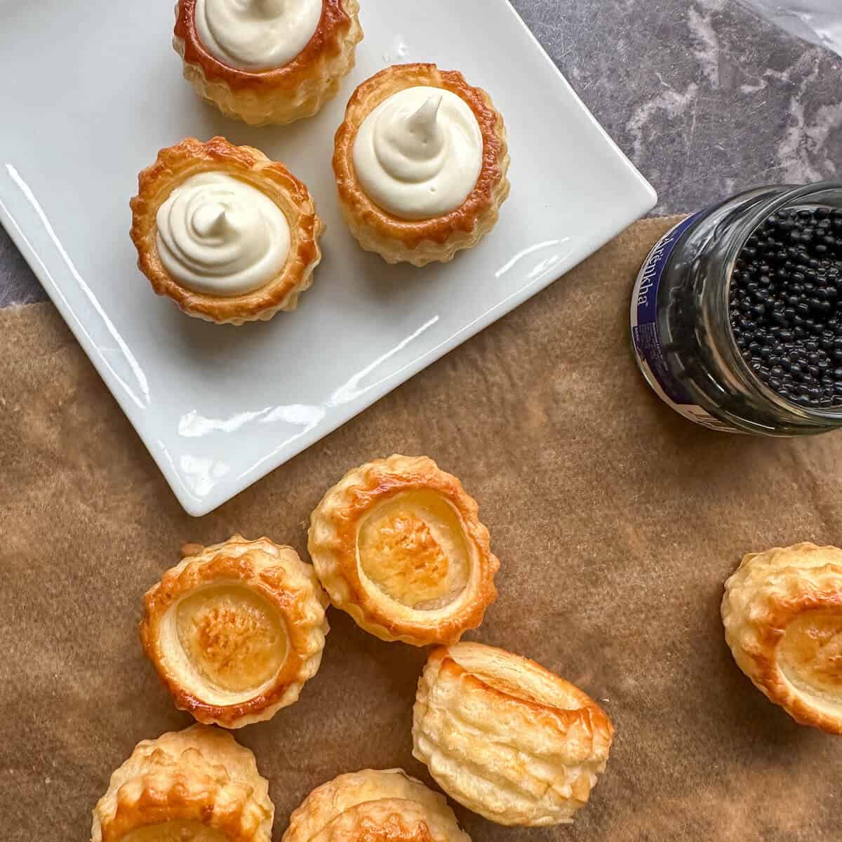 Vol au vents being filled with creme fraiche and topped with caviar. 
