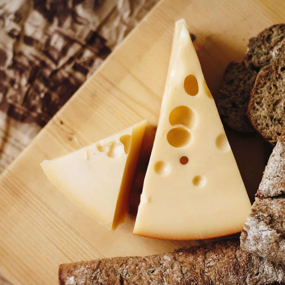 A hard Swiss cheese on a serving board. 