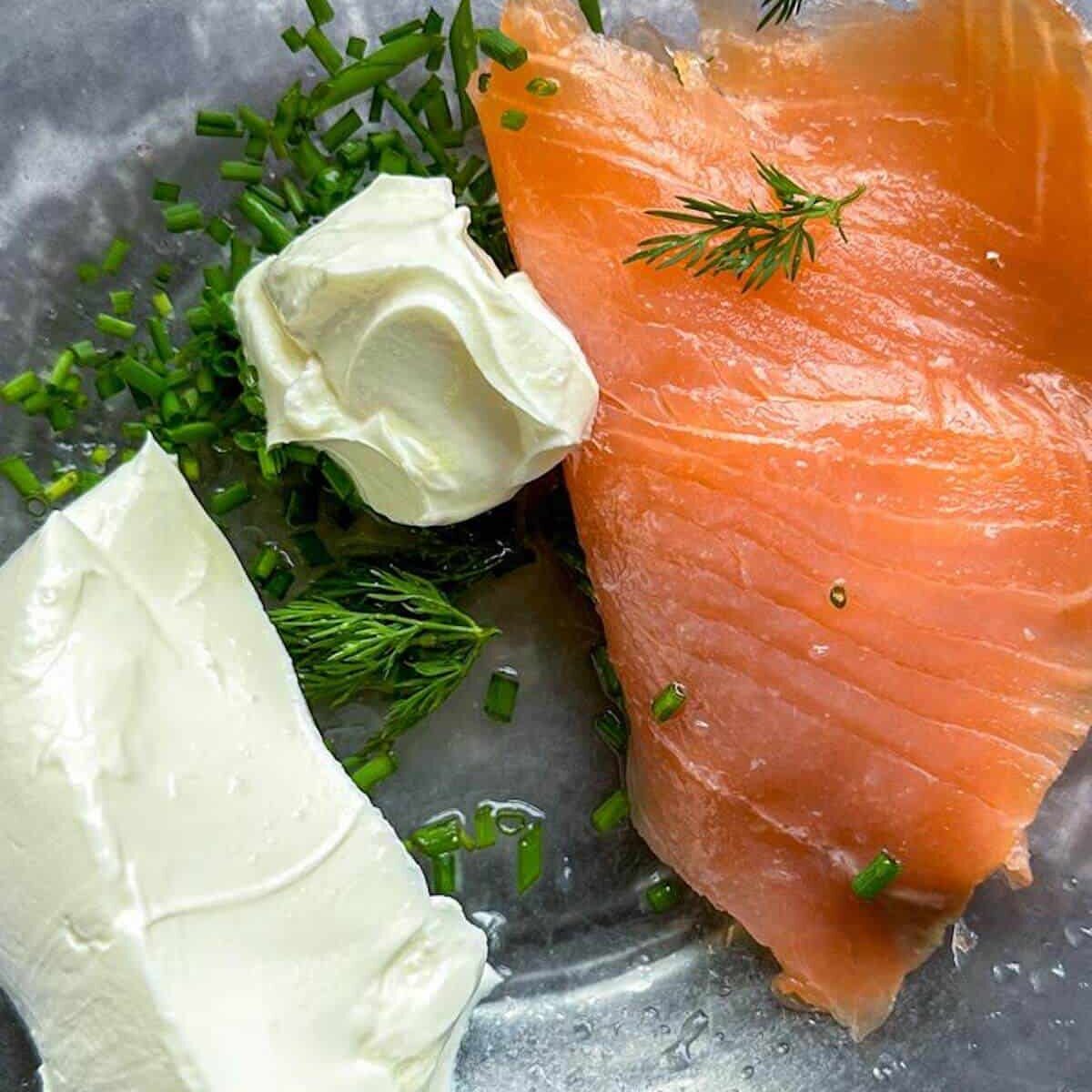 Smoked salmon, cream cheese, lemon juice and fresh dill and chives in a bowl ready to be blended into smoked salmon dip. 