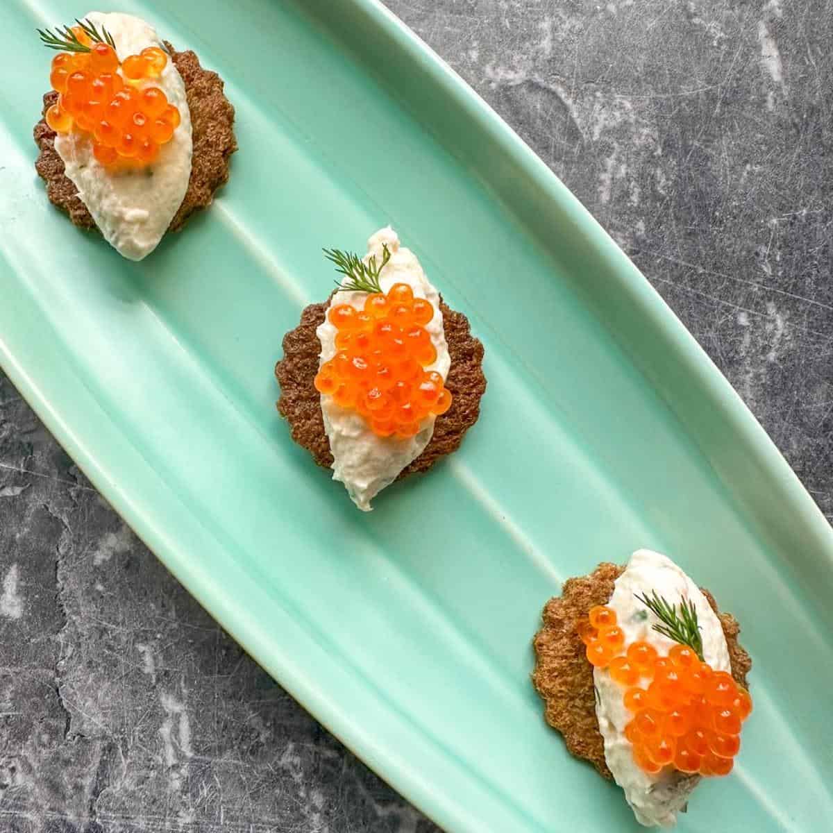 Salmon roe canapes on a serving platter.