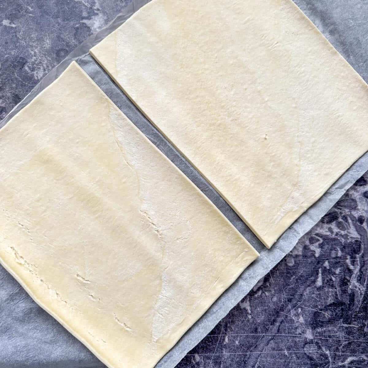 A sheet of puff pastry cut into two pieces. 