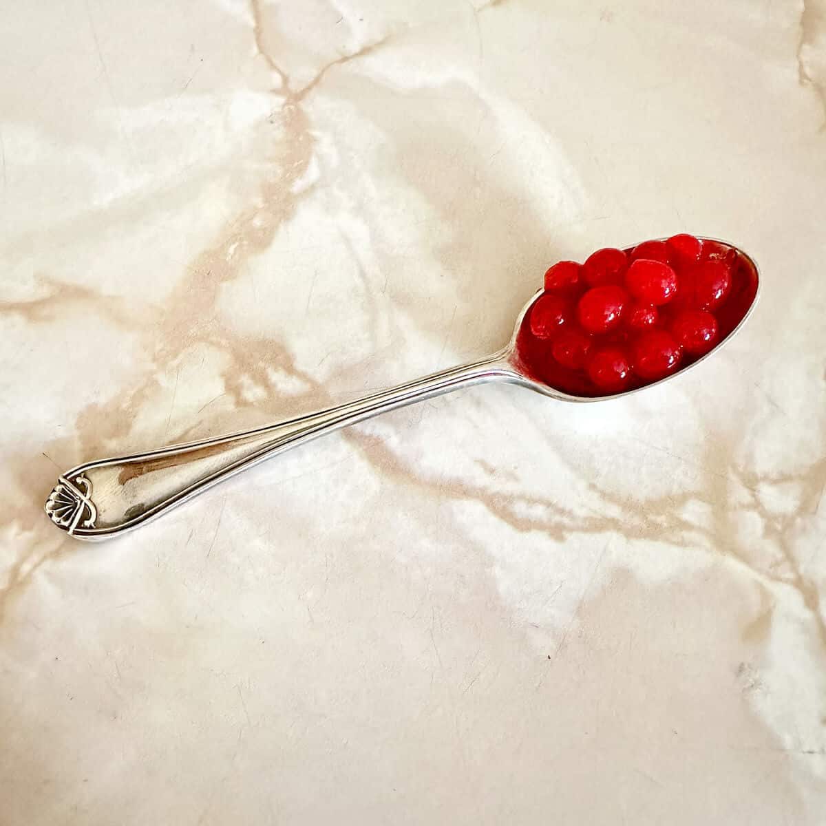 A teaspoon full of raspberry caviar to use as a garnish.
