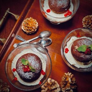 Chocolate truffle torte bombs in glass bowls on a tray with spoons.
