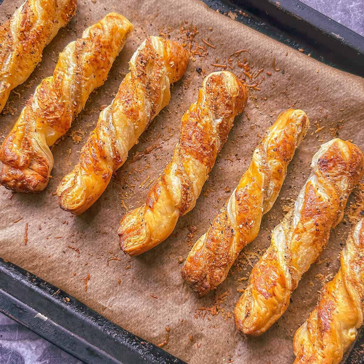 Baked parmesan cheese twists on an oven tray. 