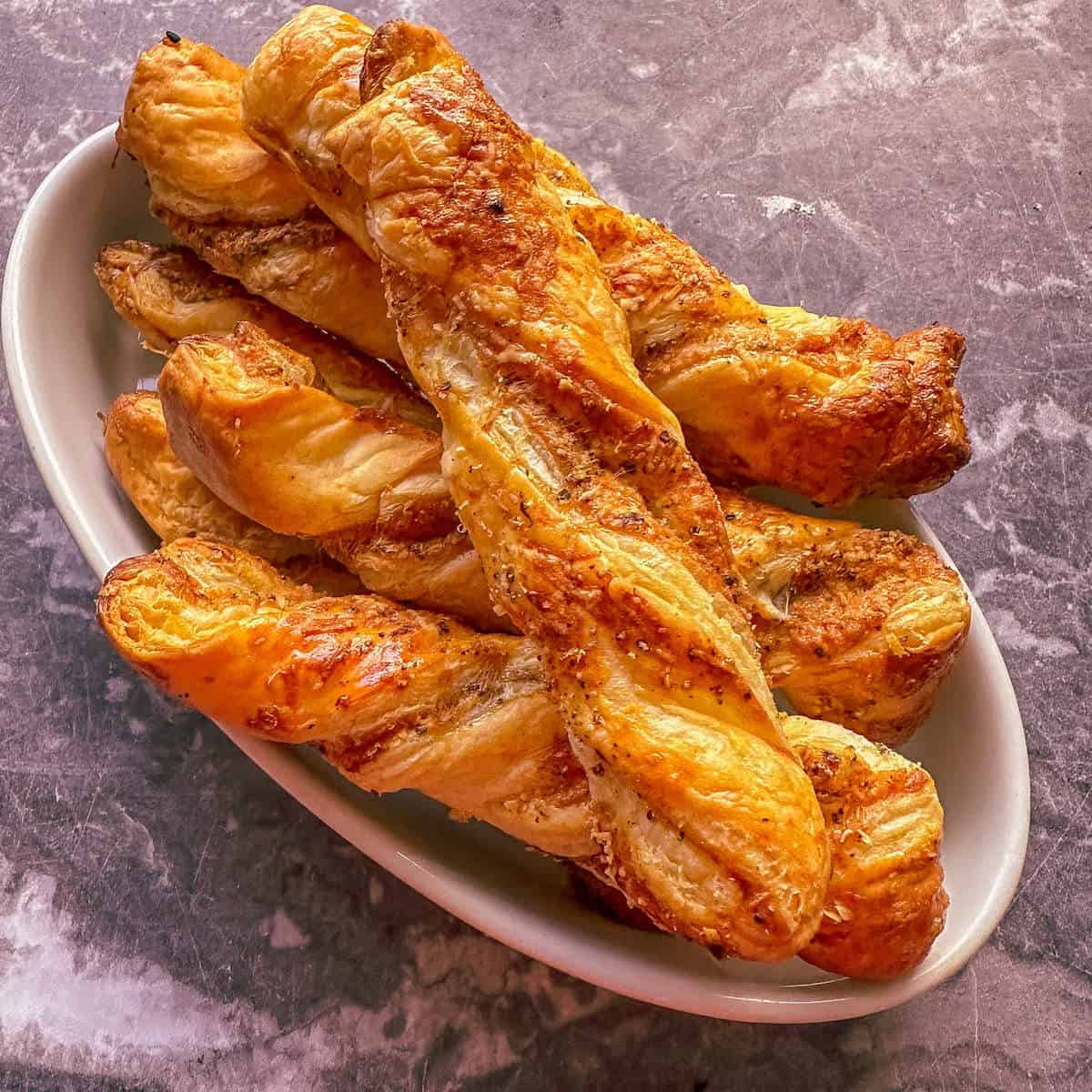 Easy Parmesan Cheese Twists With Puff Pastry in a serving dish.