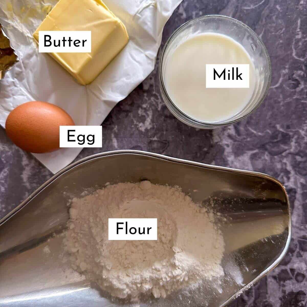 The 4 ingredients for easy homemade blinis without yeast. Egg, butter, milk and flour. 