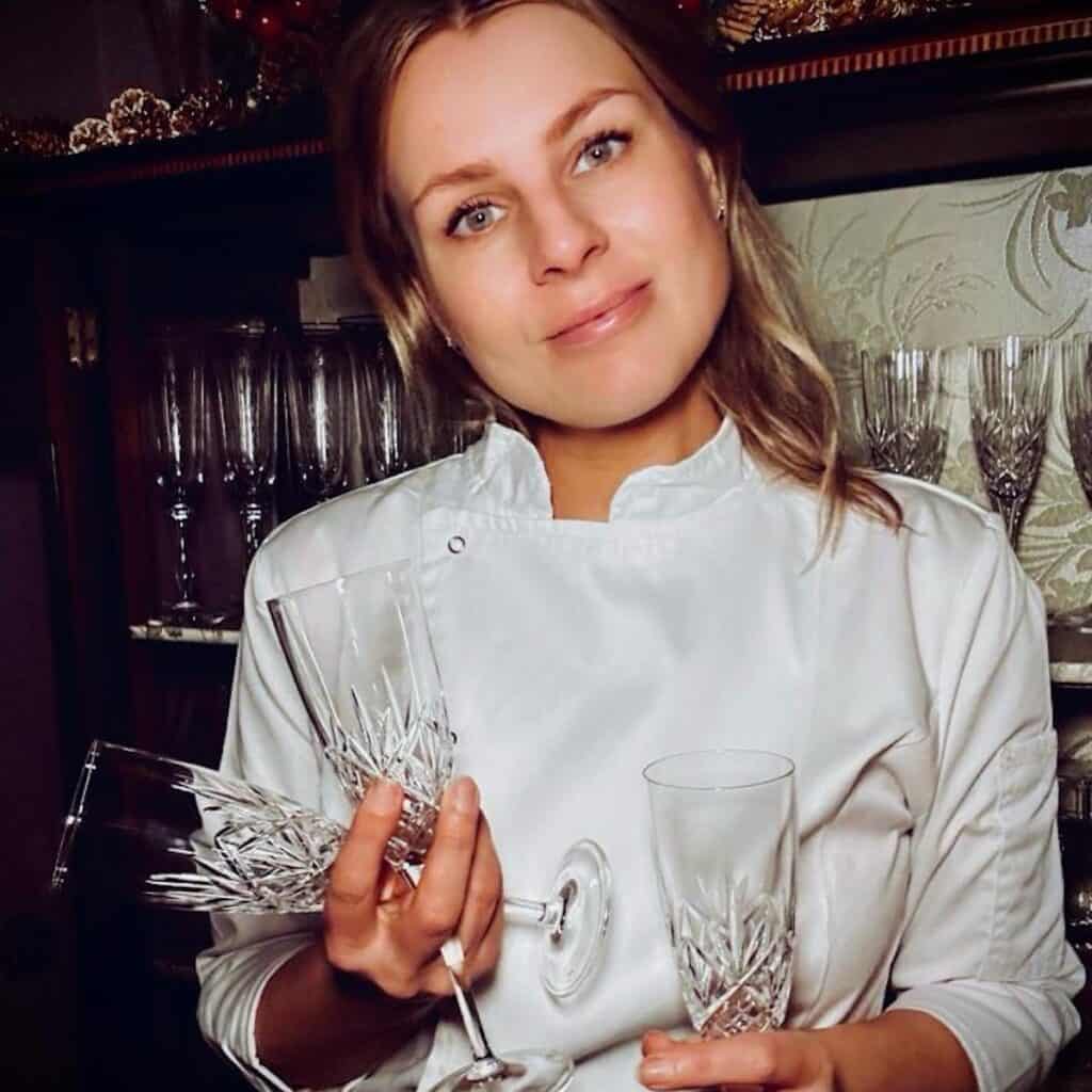 Rosanna Stevens, of Rosanna ETC, wearing chef's whites and holding champagne glasses.