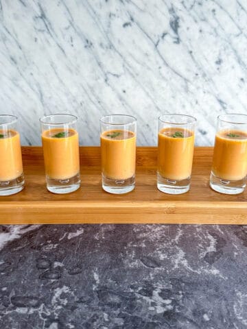 A tray of crab bisque in shot glasses, served as an amuse bouche.