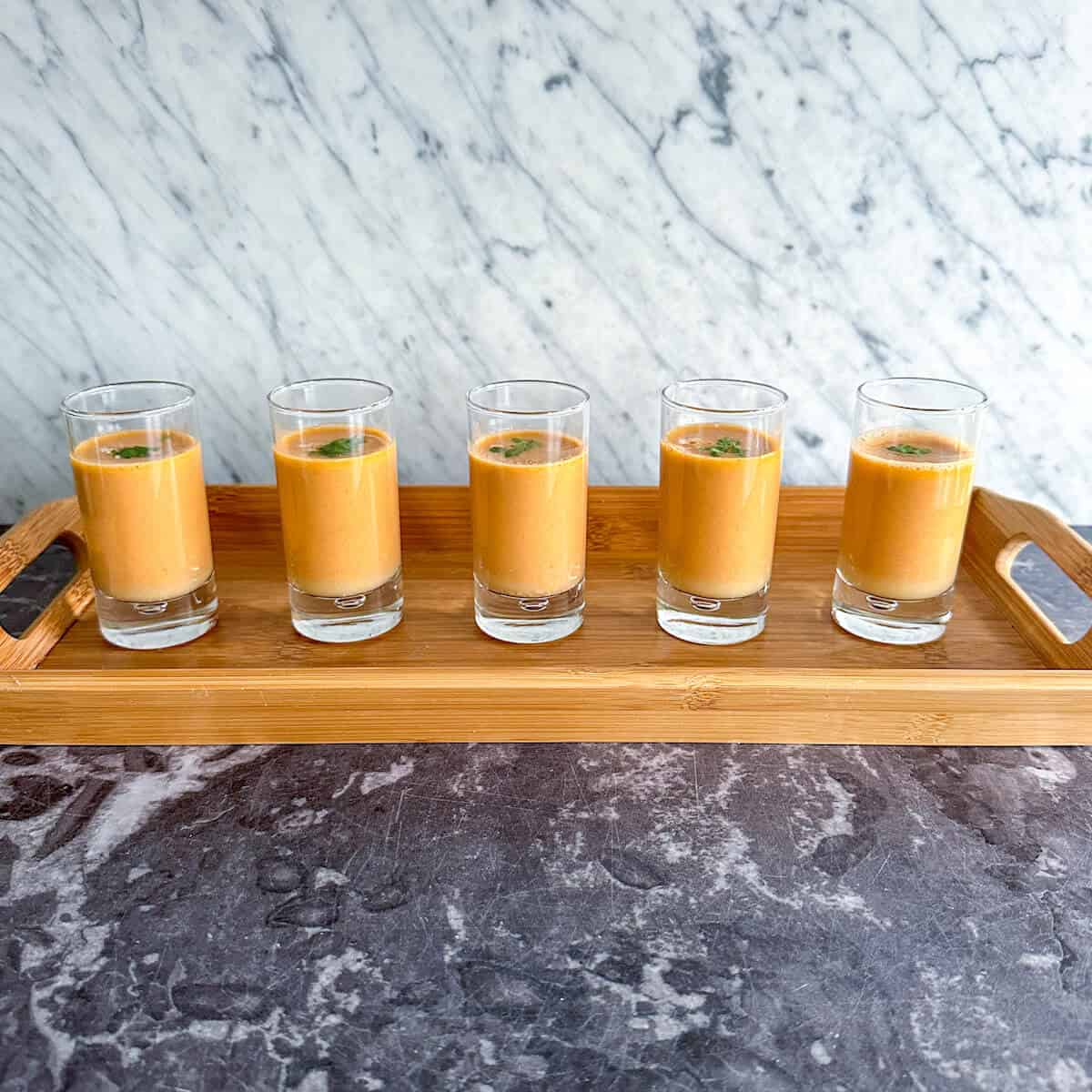 A tray of crab bisque in shot glasses, served as an amuse bouche. 